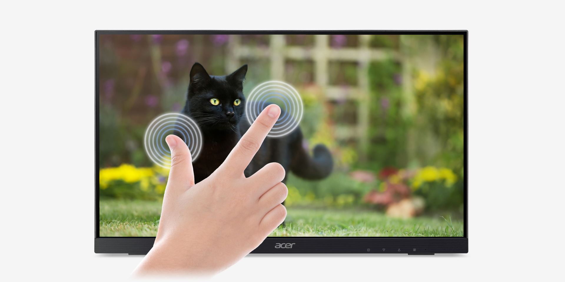 Two fingers are touching a UT2 monitor with a black cat against a backdrop of garden on it